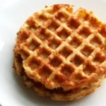 A close-up view of golden, crispy chaffles stacked on a plate, perfect for a low-carb meal or snack.