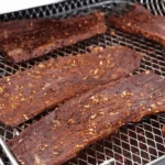 Homemade air fryer beef jerky on a plate, showcasing crispy and flavorful strips of jerky